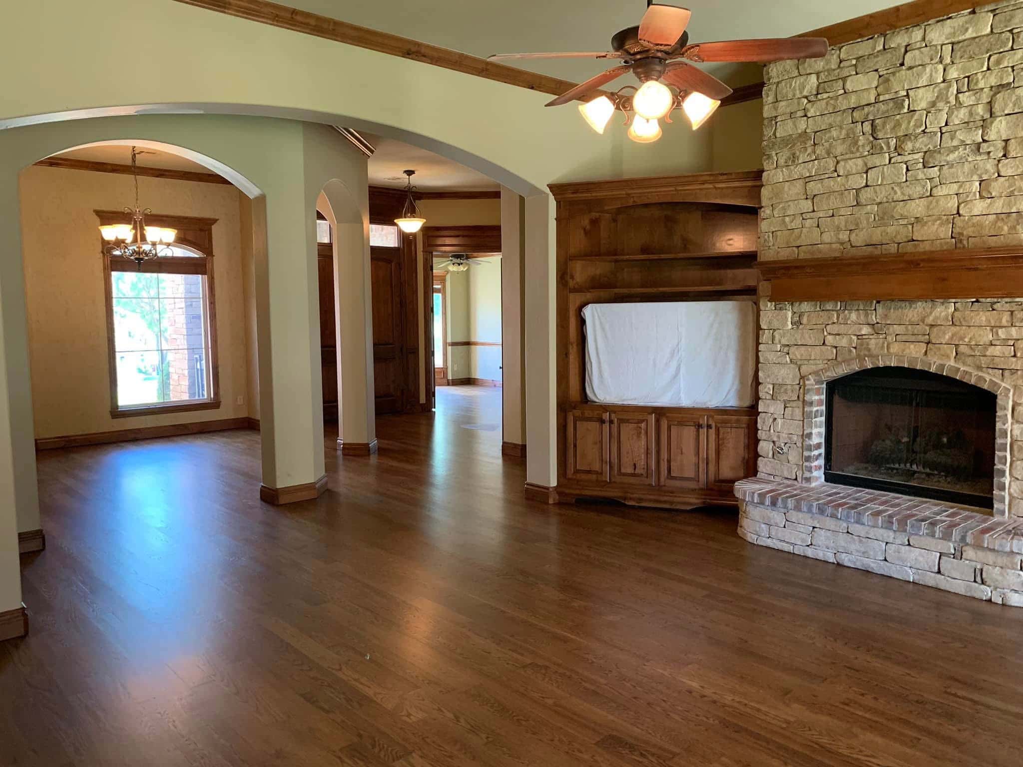 Rich hardwood flooring installation with custom built-in cabinetry and interior archways.