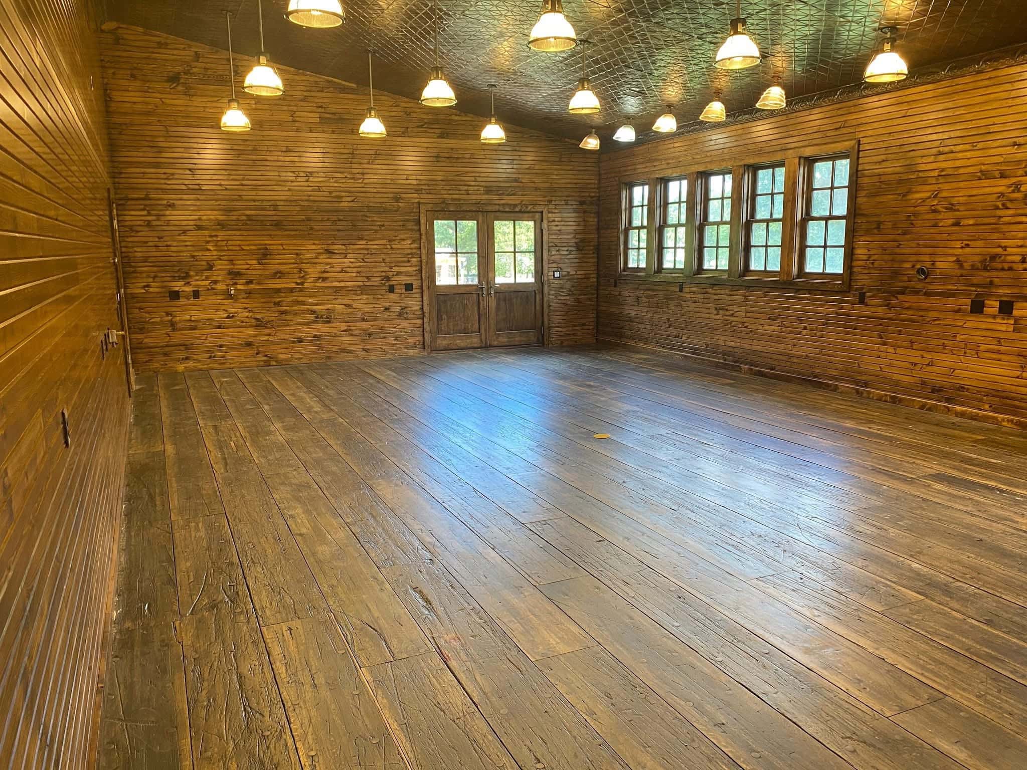 Commercial interior build-out featuring custom wood wall paneling and polished hardwood floors.