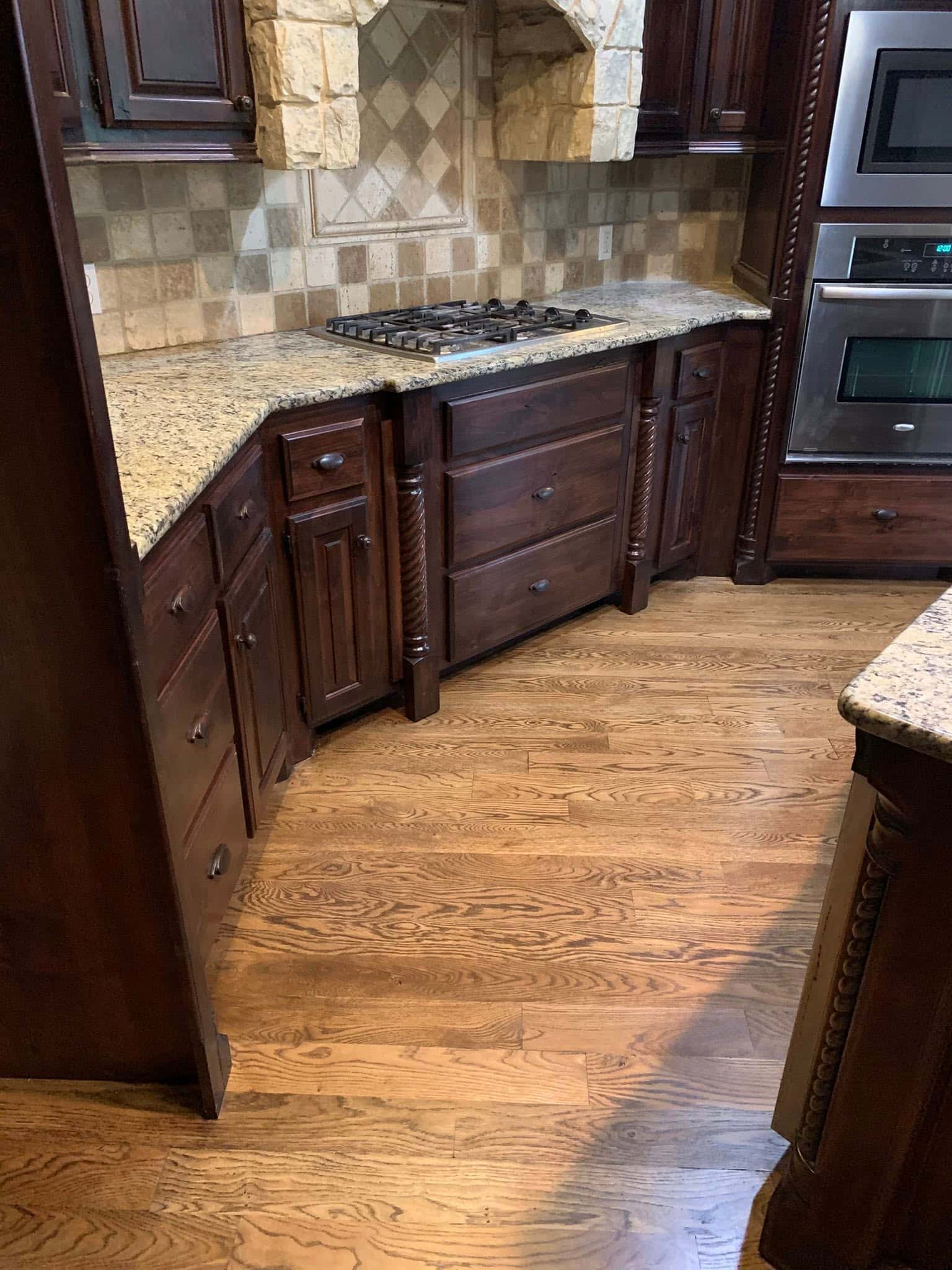Kitchen remodel in Pasadena featuring dark wood cabinetry and custom hardwood floor refinishing.