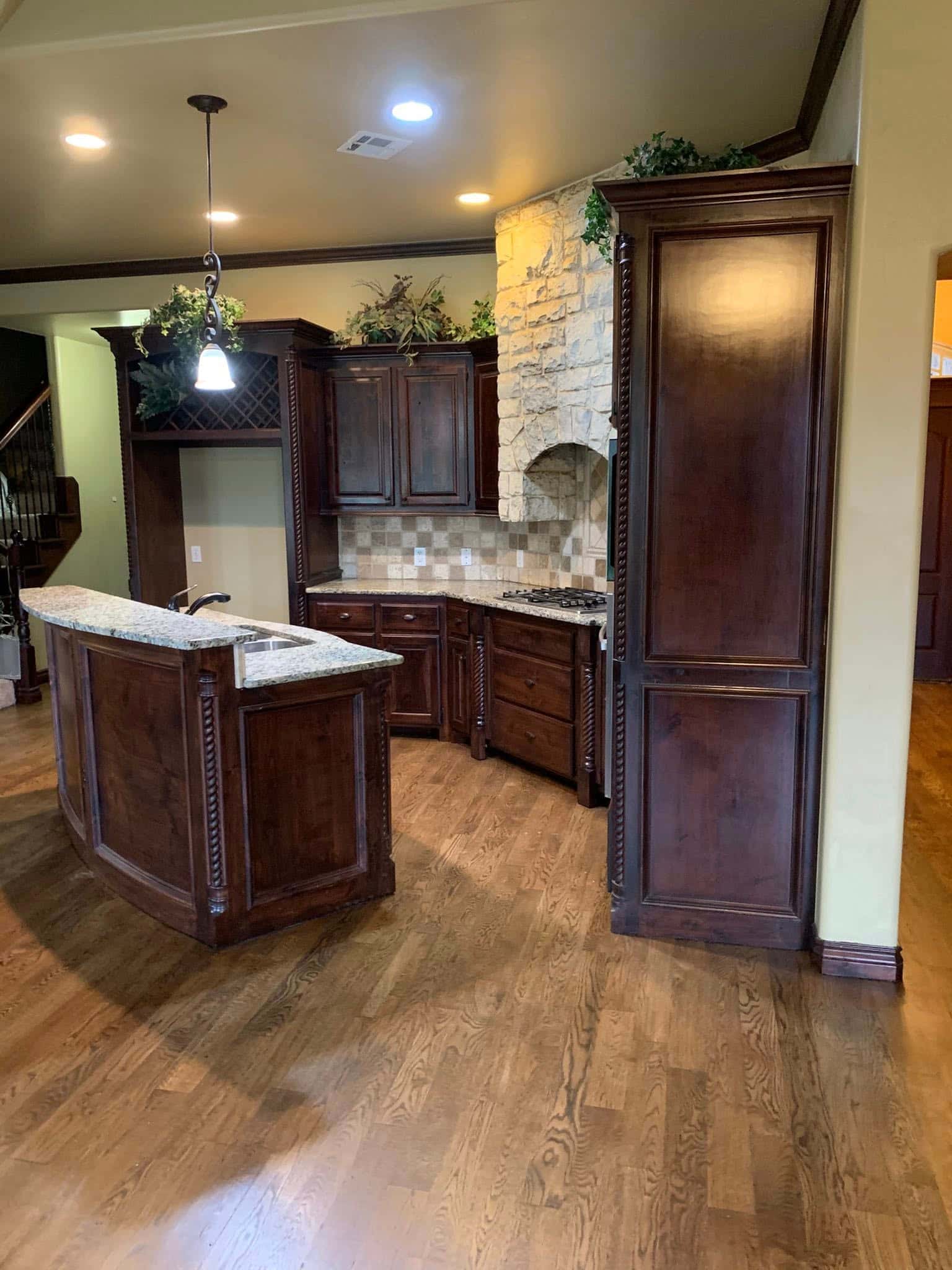 Pasadena kitchen remodel featuring custom dark cabinetry, central island, and hardwood flooring.