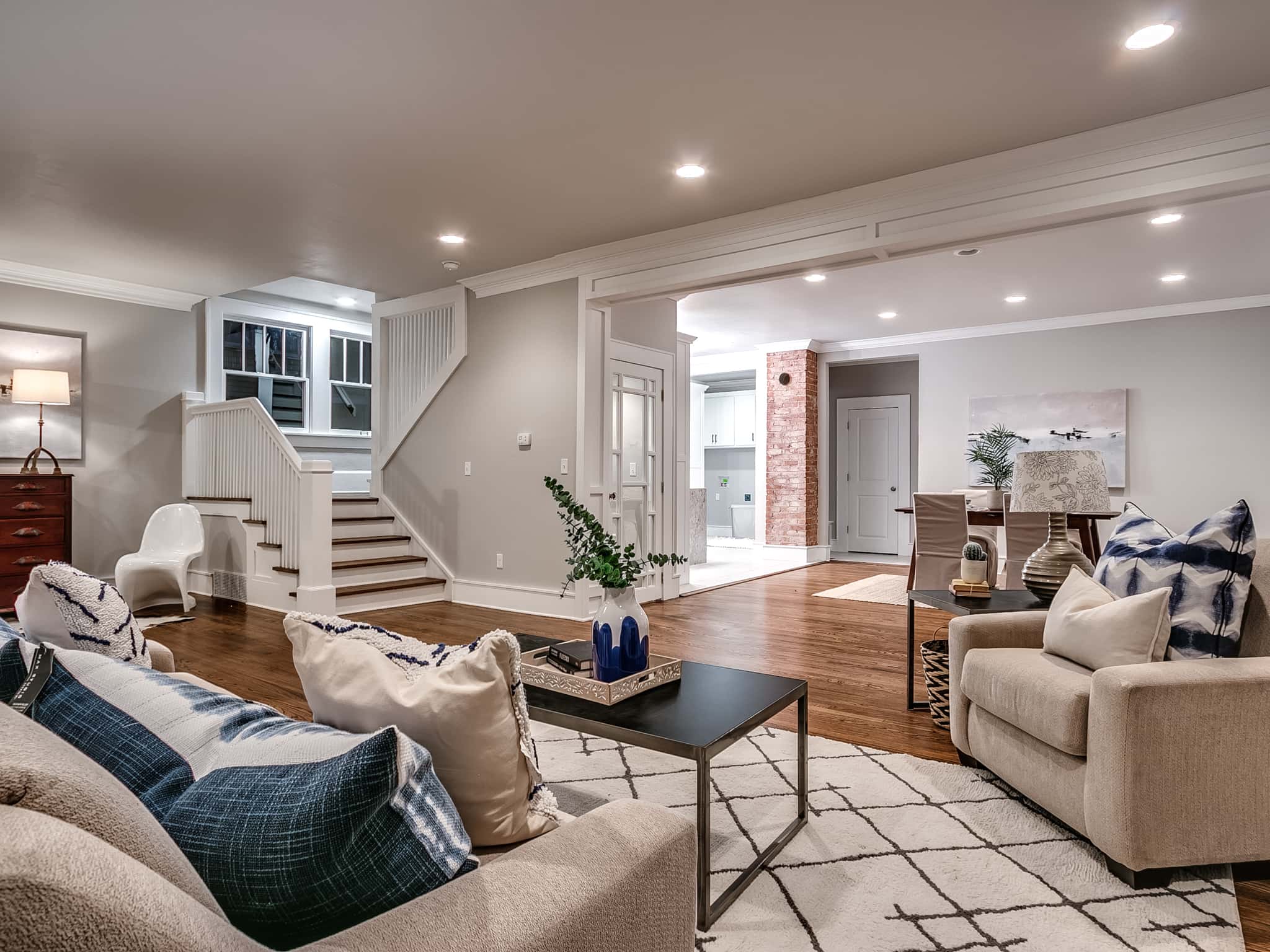 Modern open-concept living room renovation with bright light oak floors and custom trim.