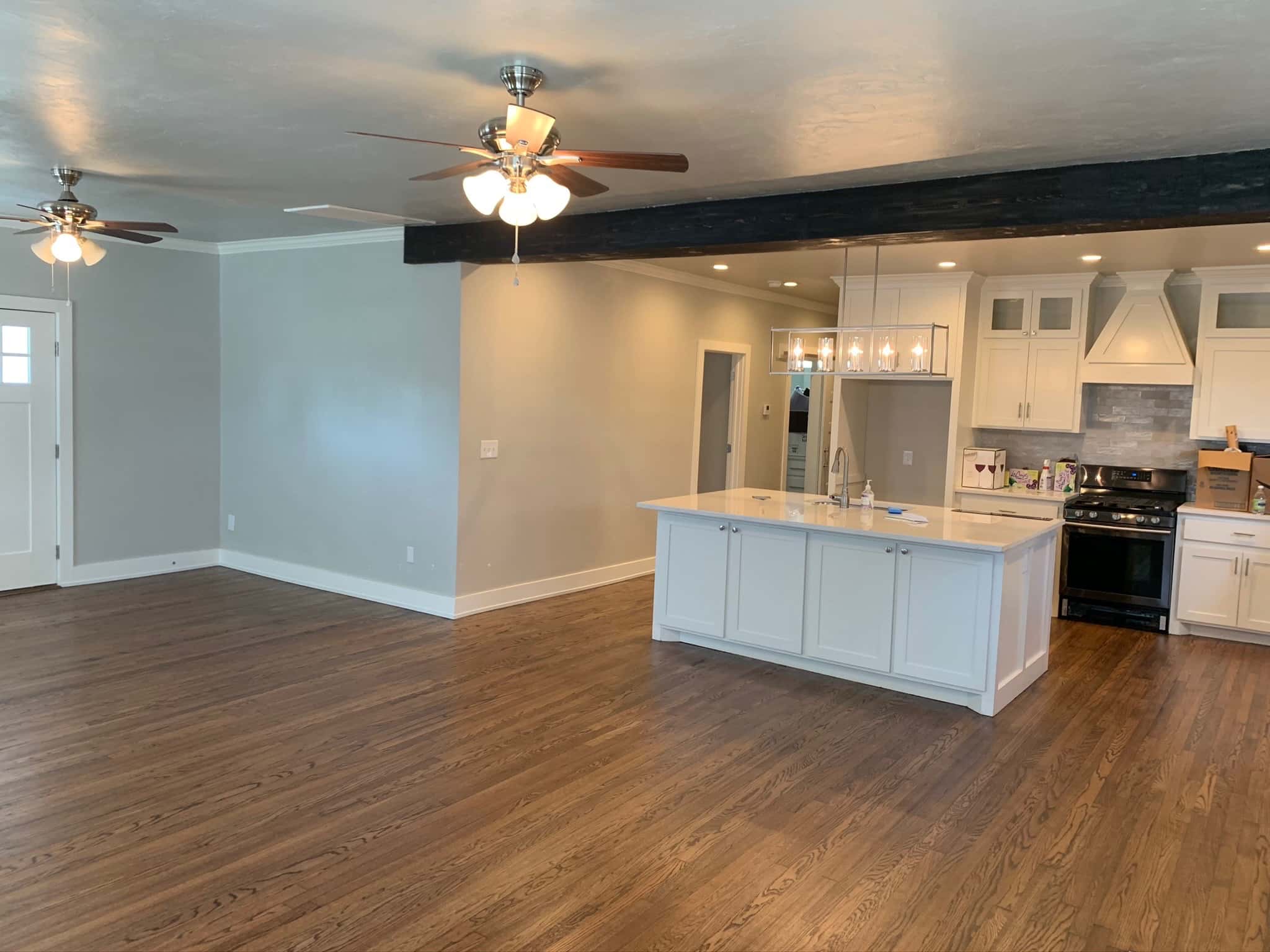 Pasadena open-concept kitchen remodel with white island, custom hardwood floors, and ceiling beams.