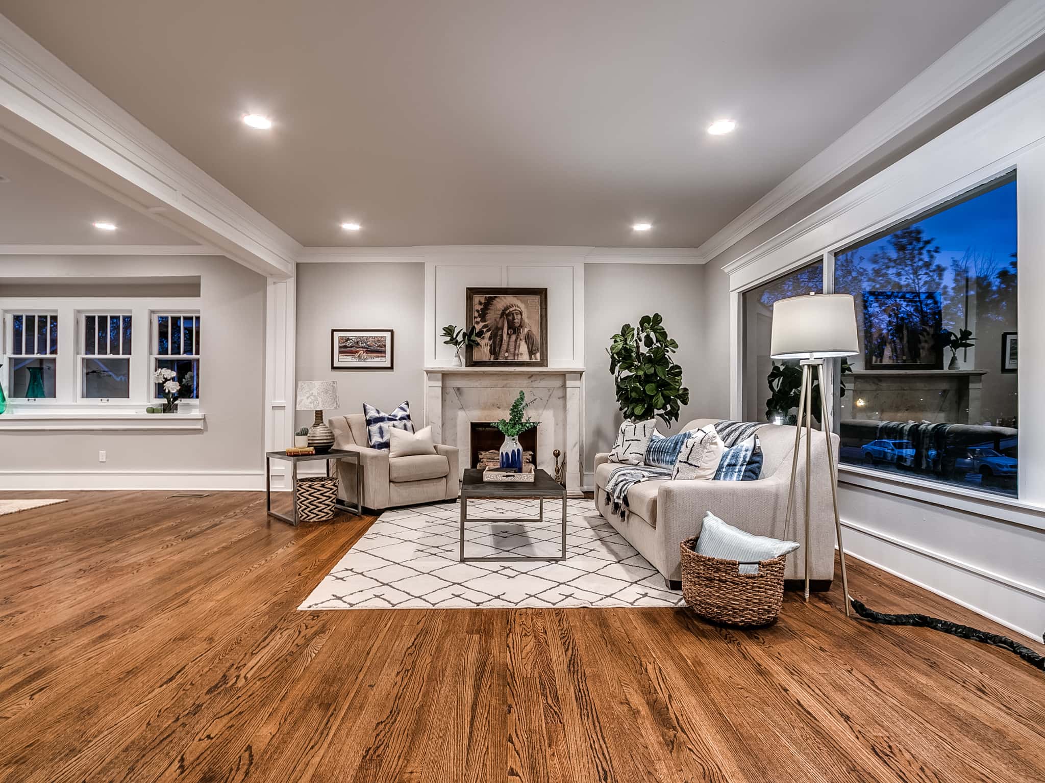Luxury living room remodel featuring custom fireplace surround and warm oak hardwood floors.